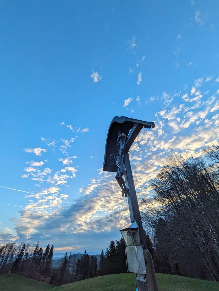 Wegkreuz vor blauem Abendhimmel mit Wolken