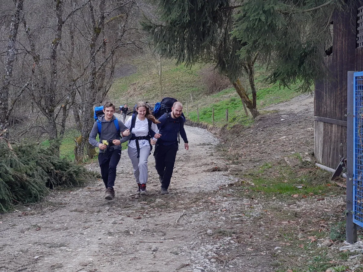Die RaRo wandern mit Rucksäcken einen Feldweg bergauf